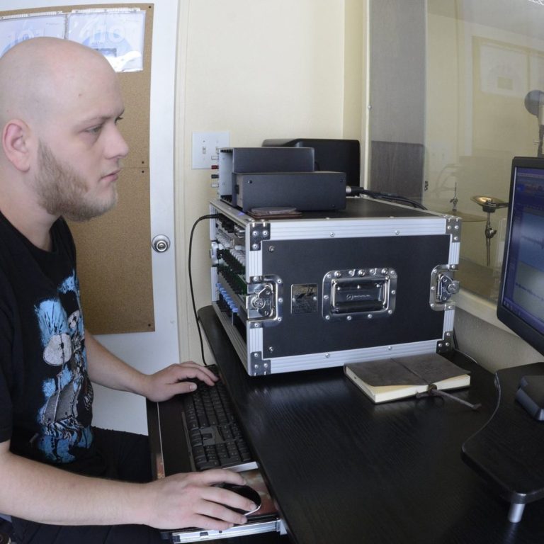 <img source='pic.gif' alt='Man recording musicians in a commercial recording studio.' />.
